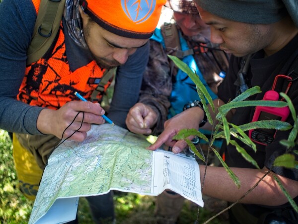 Hunters looking over a map, Rosauro Nava (NZDA)