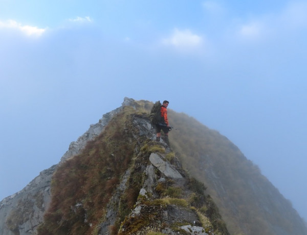 Tom walking a razorback as fog covers the mountain around us