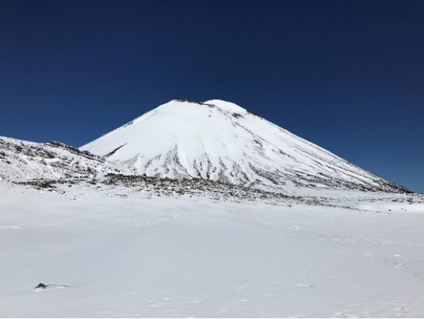 Mt Ngauruhoe blanketed in winter snow viewed from the Tongariro Alpine Crossing.