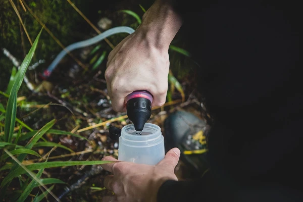 A person treating water in the outdoors.