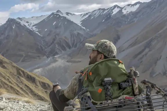 Bow hunter surveying alpine terrain
