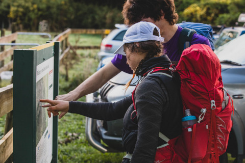 Thumbnail of Trampers pointing at signage, Caleb Smith