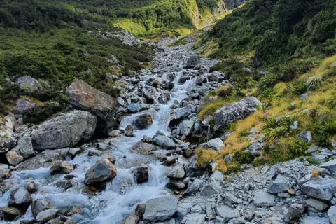 View of tramper hiking up a valley beside the West Branch of the Sabine River 